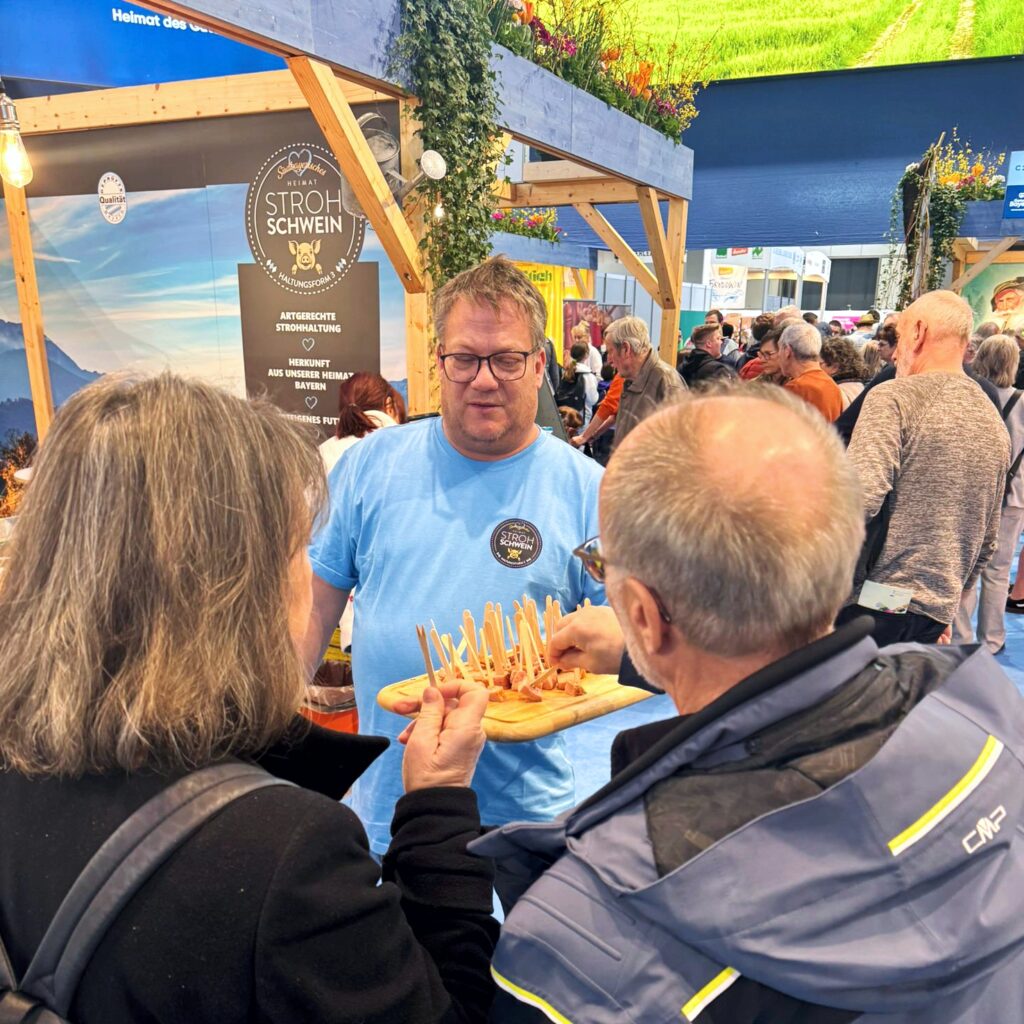 FMS Geschäftsführer Christian Otto verteilt Leberkäse Probierhappen auf der Grünen Woche in Berlin.